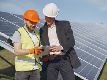 Solar installer on roof mounting panels”